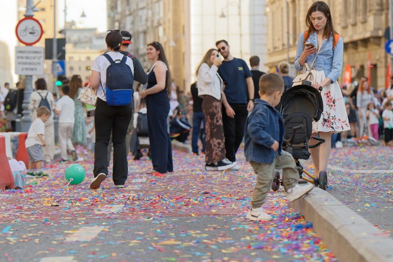 28 - Festive street celebration, with colorful confetti scattered across the ground